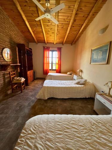a bedroom with two beds and a ceiling fan at La Maru in Villa Giardino