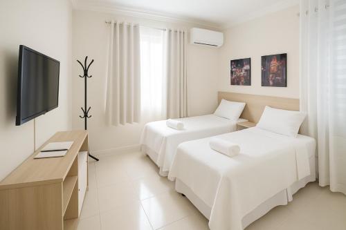 a hotel room with two beds and a television at Pousada 218 in Manaus