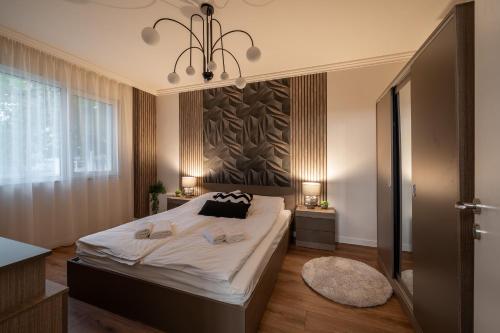 ein Schlafzimmer mit einem großen Bett und einem Kronleuchter in der Unterkunft Бизнес & Арт апартамент - до Панаира и Капана in Plowdiw