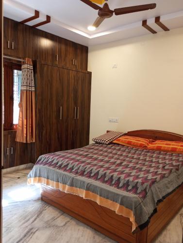 a bedroom with a large bed with wooden cabinets at EnDai House - Kalyanpuri, Uppal in Hyderabad