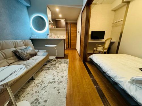 une chambre avec un lit, un canapé et une télévision dans l'établissement LuxurySweet 博多駅南61, à Fukuoka