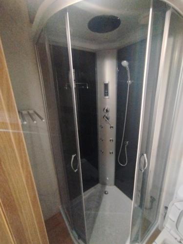 a shower with a glass door in a bathroom at Pérola da Serra in Fundão