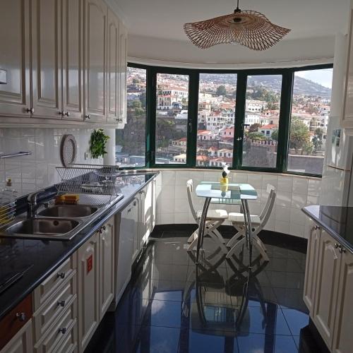 a kitchen with a table and a view of a city at Apartamento Silvestre Freitas in Funchal