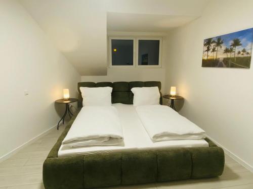 a large green bed in a room with two tables at Anacoco Deluxe Home in Herzogenrath