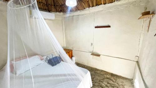 バカラルにあるCabañas Alma Verdeのベッドルーム(蚊帳付きのベッド付)