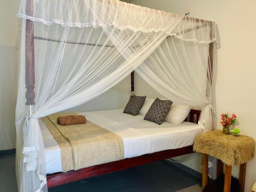 una cama con dosel en una habitación en The Golden Sand Villa in Unawatuna, en Unawatuna