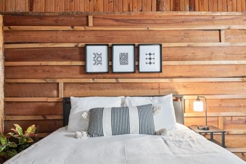 a bedroom with a bed with four pictures on the wall at Wooden suite #3 in Madill