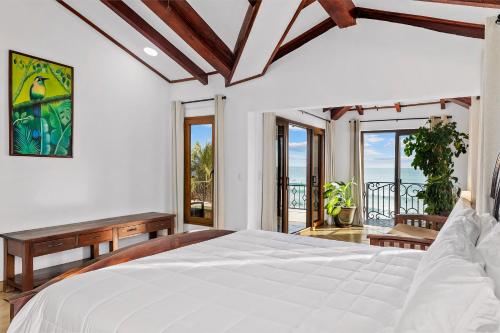a bedroom with a bed with a view of the ocean at Casa Colorados in Tola