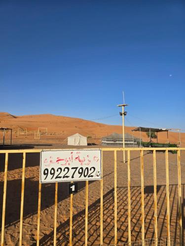 un panneau sur une clôture dans le désert dans l'établissement عزبة ابو حمزة, à Al Raka