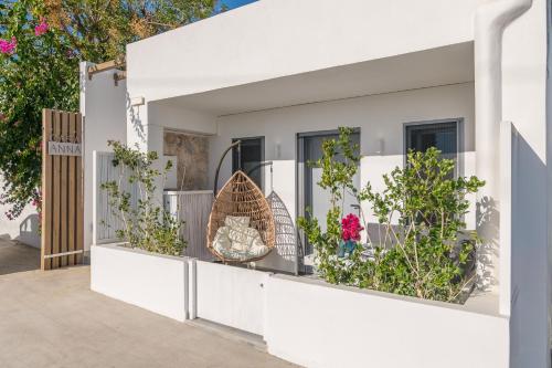 a white house with flowers on the balcony at CASA ANNA BOUTIQUE SUITE Apartment New in Adamas