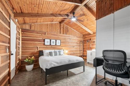 a bedroom with a bed and a desk and a chair at Wooden suite #7 in Madill