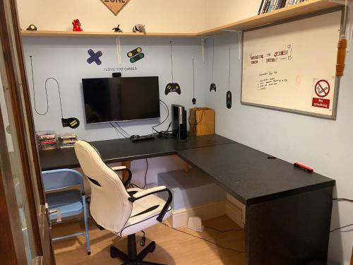 an office with a black desk and a white chair at Johaan in Caernarfon
