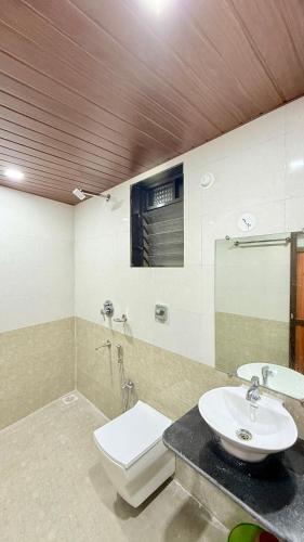 a bathroom with a toilet and a sink at Swara Homestay in Bārsiv