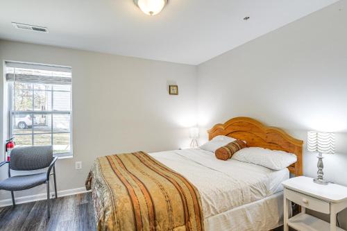 ein Schlafzimmer mit einem Bett und einem Stuhl und einem Fenster in der Unterkunft Suburban Comfort in Bowie! Apartment with Patio in Bowie