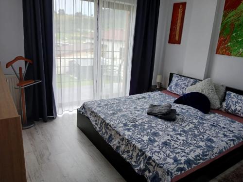 a bedroom with a bed and a large window at Lux - Confort in Sînpetru