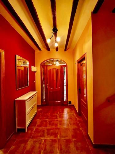 a hallway with red and yellow walls and a red door at La Casa Azul in Cehegín