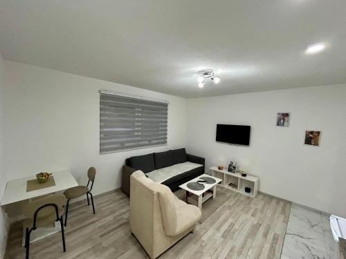 una sala de estar con un sofá y una mesa en Apartman M, 