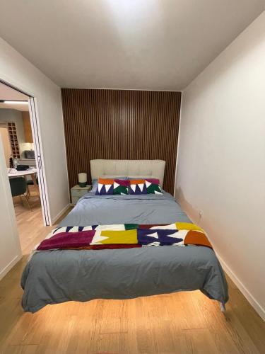 a bedroom with a large bed with colorful blankets at Ins apartment - 2 bedrooms - metro parking prive in Bagnolet
