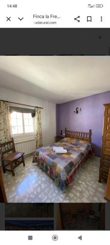 a bedroom with a bed in a purple room at La murallita de Aroa in Cañete