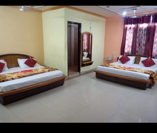 ein Schlafzimmer mit zwei Betten und einem Spiegel in der Unterkunft Hotel Bharat Residency in Amritsar