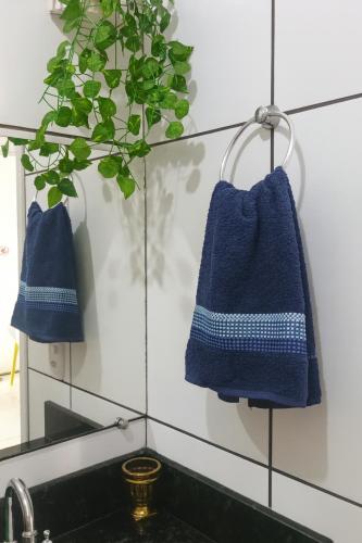 a bathroom with two blue towels hanging next to a sink at Mini Garden kitnet in Paranavaí
