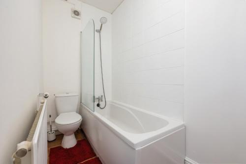 a white bathroom with a toilet and a bath tub at Immingham Contractors stay in Immingham