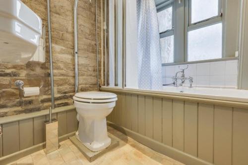 a bathroom with a toilet and a sink and a window at Canal Cottage Rodley Leeds, 5 miles LBA Airport in Leeds