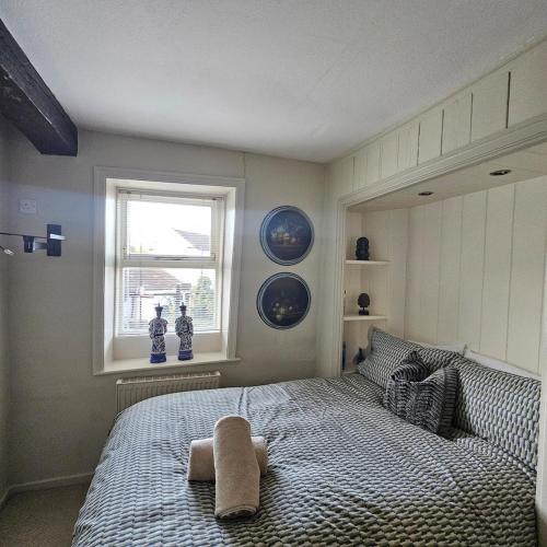 a bedroom with a bed with a towel on it at Canal Cottage Rodley Leeds, 5 miles LBA Airport in Leeds