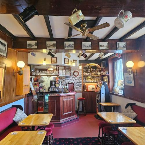 a restaurant with a bar with wooden tables and chairs at Canal Cottage Rodley Leeds, 5 miles LBA Airport in Leeds