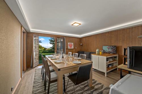a dining room with a long table and chairs at Chalet Calin - Business & Familles in Arzier