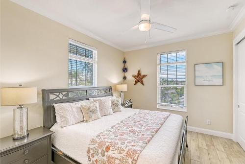 a bedroom with a bed and two windows at Casa Coquina - 1038U in Siesta Key
