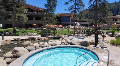 a swimming pool in a yard with rocks and a resort at Dav's Slopeside King Studio -- Resort & Spa at Everline in Olympic Valley