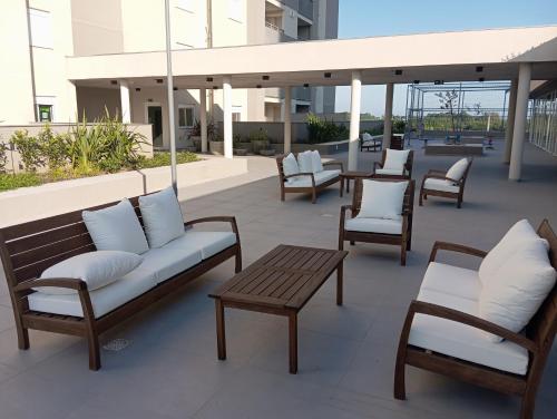 a group of benches and chairs on a patio at Apartamento com piscina, terraço, churrasqueira e estacionamento in Pelotas