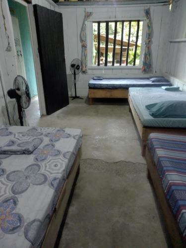 a room with three beds and a window at Hostal ladrillerossurf in Buenaventura