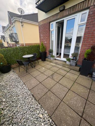 a patio with a table and chairs in front of a house at Castlejane Apartment in Cork