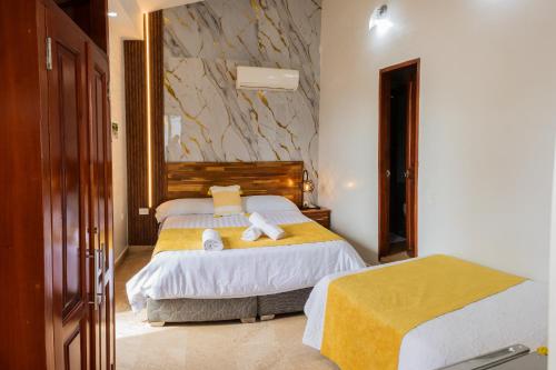 a bedroom with two beds with towels on them at Hotel Casa Centenario Getsemaní in Cartagena de Indias