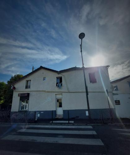 een wit gebouw met een straatlicht ervoor bij Le Berkane in Argenteuil