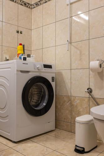 a washing machine in a bathroom with a toilet at Afroditi's Apartment Superb View in Gythio