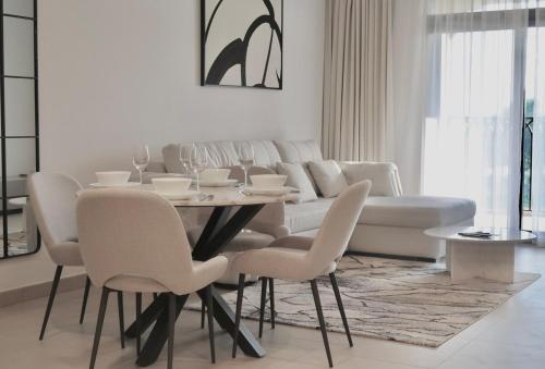 a white living room with a table and chairs at Skyline Views at Madinat Jumeirah Living in Dubai