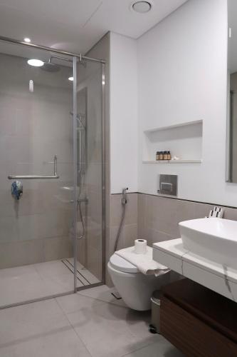 a bathroom with a shower and a toilet and a sink at Skyline Views at Madinat Jumeirah Living in Dubai