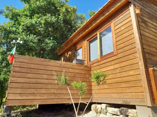 a wooden cabin with a fence in front of it at Quinta Da Bolota Small Cabin in Alvaiázere