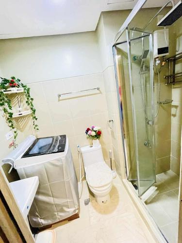a bathroom with a shower and a toilet and a sink at SM Bicutan Quick Staycation PH in Manila