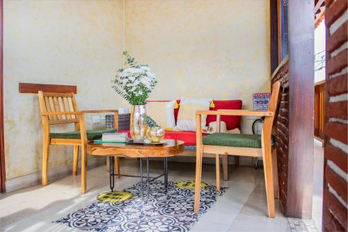 a room with two chairs and a table with a vase of flowers at Hotel Casa Centenario Getsemaní in Cartagena de Indias