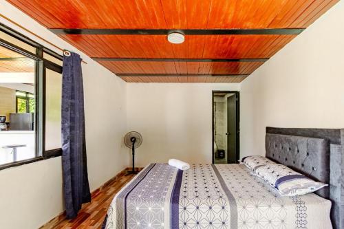 a bedroom with a bed with a wooden ceiling at Quinta Villanueva in Ibagué