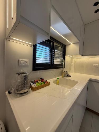 a kitchen counter with a sink and a window at אחוזת תכשיט in Sifsufa