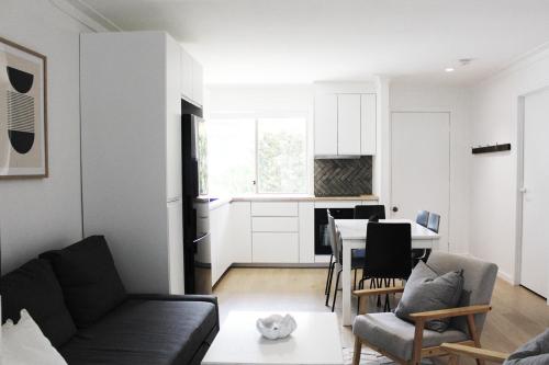 a living room with a couch and a table at Beach Side Villa Walk to Shops-Pub-Beach Newly Renovated in Byron Bay