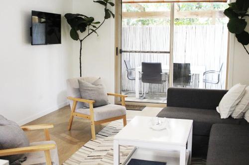 a living room with a couch and chairs and a table at Beach Side Villa Walk to Shops-Pub-Beach Newly Renovated in Byron Bay