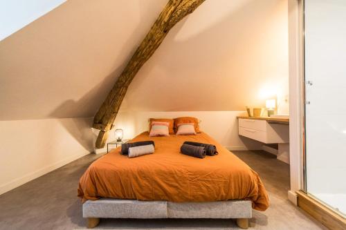 una camera da letto con un letto con copriletto arancione di Villa Chadourne - LE CONQUERANT T2 Moderne a Brive-la-Gaillarde