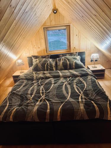 a bedroom with a large bed with two lamps at Zaciszna Idylla Domek z jacuzzi nad Jeziorem Złotnickim Karłowice in Olszyna