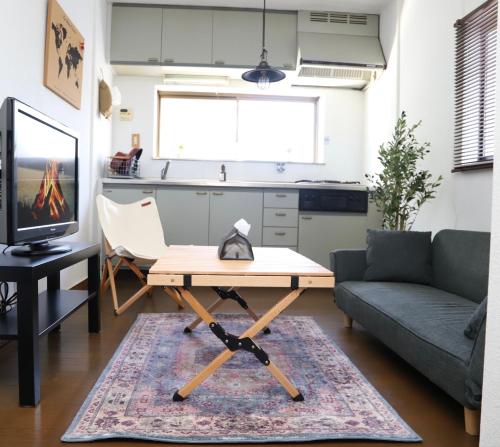 ein Wohnzimmer mit einem Couchtisch und einer Couch in der Unterkunft いちえ堂 in Kashihara